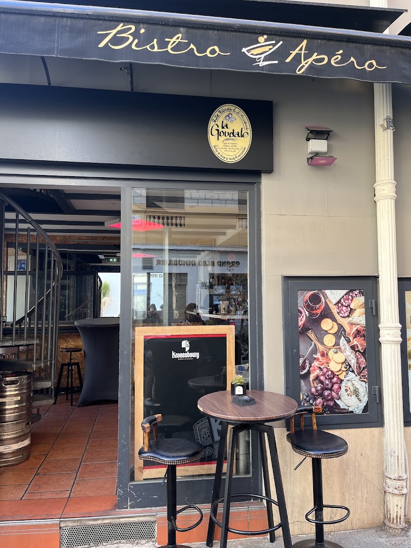 L’entrée de Bistro Apéro avec son store et ses tables hautes